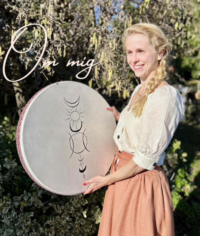 Portræt af Rebekka, stifter af Cura Cordis i Roskilde, smilende står i haven, holder en ocean drum med sjamanske symboler. Hun er neurologisk intensivsygeplejerske og master public health,som kombinere videnskab og holistisk tilgang mod stress